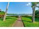 Scenic water view of the inter coastal waterway and boat docks through a manicured yard and trees at 113 Lagoon Ct, New Smyrna Beach, FL 32169
