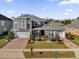 Two-story house with gray siding, white garage doors, and landscaped yard at 1409 Arbitus Cir, Oviedo, FL 32765