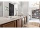 Double vanity bathroom with dark brown cabinets and a large mirror at 1409 Arbitus Cir, Oviedo, FL 32765