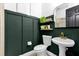 Modern bathroom with dark green walls, white pedestal sink, and gold fixtures at 1409 Arbitus Cir, Oviedo, FL 32765