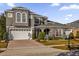 Two-story house with gray siding, white garage doors, and landscaped yard at 1409 Arbitus Cir, Oviedo, FL 32765