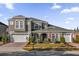 Two-story house with gray siding, white garage doors, and landscaped yard at 1409 Arbitus Cir, Oviedo, FL 32765