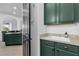 Functional laundry room with green cabinets, a utility sink, and built-in shelving at 1409 Arbitus Cir, Oviedo, FL 32765