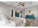 Bright main bedroom with king bed, teal dresser, and access to en-suite bathroom at 1409 Arbitus Cir, Oviedo, FL 32765