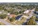 Aerial view of a single-story home showcasing a manicured lawn, trees, and access to local streets at 1423 Palmetto St, New Smyrna Beach, FL 32168