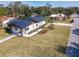 Aerial view of modern home with a dark roof, lush landscaping, and long driveway at 1423 Palmetto St, New Smyrna Beach, FL 32168