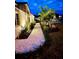 Night view of walkway with gravel, lush landscaping, and outdoor lighting at 1423 Palmetto St, New Smyrna Beach, FL 32168