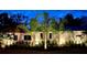 Exterior view of home with manicured landscaping and beautiful outdoor lighting at 1423 Palmetto St, New Smyrna Beach, FL 32168