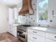 Well-appointed kitchen featuring custom range hood, stainless steel range and designer tile backsplash at 1423 Palmetto St, New Smyrna Beach, FL 32168