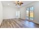 Bright living room with wood floors, ceiling fan, and french doors leading to the backyard at 1423 Palmetto St, New Smyrna Beach, FL 32168