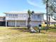 Two-story house with metal roof, balcony, and landscaped lawn at 15 Richmond Dr, New Smyrna Beach, FL 32169