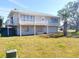 Two-story house with metal roof, balcony, and landscaped lawn at 15 Richmond Dr, New Smyrna Beach, FL 32169