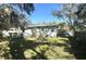 Large backyard with green grass, trees, and a deck at 1506 Palmetto St, New Smyrna Beach, FL 32168