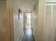 Clean hallway with wood-look floors and linen closets on either side at 1506 Palmetto St, New Smyrna Beach, FL 32168