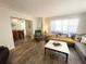 Cozy living room featuring neutral walls, wood-look flooring, and access to the dining area at 1506 Palmetto St, New Smyrna Beach, FL 32168