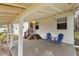 Covered porch with wooden stairs and blue chairs at 1596 Elizabeth St, New Smyrna Beach, FL 32168