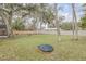 Large grassy backyard with wooden fence and fire pit at 1622 Pine Tree Dr, Edgewater, FL 32132