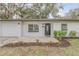 Updated home exterior with modern dark door and landscaping at 1622 Pine Tree Dr, Edgewater, FL 32132