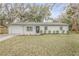 Newly renovated home with a white exterior and a gray roof at 1622 Pine Tree Dr, Edgewater, FL 32132