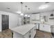 Kitchen island with white cabinets and quartz countertop, offering extra prep space at 1622 Pine Tree Dr, Edgewater, FL 32132