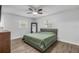 Main bedroom with king-size bed, ceiling fan, and large mirror at 1622 Pine Tree Dr, Edgewater, FL 32132