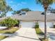 Exterior of a villa featuring a two-car garage and landscaping at 1938 Turnbull Lakes Dr, New Smyrna Beach, FL 32168