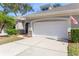 Exterior view of a villa with a two-car garage and stone accents at 1938 Turnbull Lakes Dr, New Smyrna Beach, FL 32168