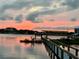 Relaxing dock area on the water, perfect for enjoying peaceful evenings and sunset views of the surrounding scenery at 2 Richmond Dr, New Smyrna Beach, FL 32169