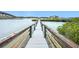 Wooden walkway leads to a pier over the calm water at 2 Richmond Dr, New Smyrna Beach, FL 32169