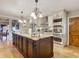 Large kitchen island with granite countertop and decorative lighting at 2 Richmond Dr, New Smyrna Beach, FL 32169