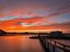 Scenic waterfront view showcasing a vibrant sunset over the tranquil waters, reflecting orange and pink hues at 2 Richmond Dr, New Smyrna Beach, FL 32169