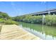 Wooden dock extending into calm water with mangrove trees and bridge in background at 2 Richmond Dr, New Smyrna Beach, FL 32169