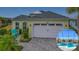 House exterior featuring a two-car garage and a captivating pool and patio area at 205 Blue Starfish Pl, Daytona Beach, FL 32124