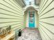 Charming front entrance featuring a turquoise door, decorative wreath, and a cozy, covered porch area at 205 Blue Starfish Pl, Daytona Beach, FL 32124