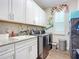 Laundry room with white cabinets and a side folding table at 205 Blue Starfish Pl, Daytona Beach, FL 32124