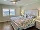 King-size bed in bedroom with water views and updated flooring at 2100 N Peninsula Ave # 216, New Smyrna Beach, FL 32169