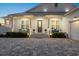 White farmhouse with a welcoming porch, a two-car garage, and a gray roof at 2302 S Atlantic Ave, New Smyrna Beach, FL 32169