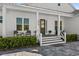 Front porch with gray floor, white columns, and dark door at 2302 S Atlantic Ave, New Smyrna Beach, FL 32169