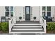 Front porch with gray floor, white columns, and dark door at 2302 S Atlantic Ave, New Smyrna Beach, FL 32169