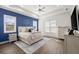 Main bedroom with blue accent wall, large bed, and walk-in closet at 2302 S Atlantic Ave, New Smyrna Beach, FL 32169