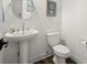 Small powder room with pedestal sink, toilet, and wood-look floors at 2302 S Atlantic Ave, New Smyrna Beach, FL 32169