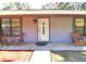 Quaint front porch with seating area and landscaping at 2309 Lime Tree Dr, Edgewater, FL 32141