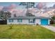 White brick ranch house with teal accents, a blue garage door, and a well-maintained lawn at 2325 Willow Oak Dr, Edgewater, FL 32141