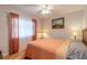 Bright bedroom with coral bedding, ceiling fan, and hardwood floors at 2717 Needle Palm Dr, Edgewater, FL 32141