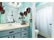 Bathroom with light blue vanity, shower, and decorative shelving at 2720 Queen Palm Dr, Edgewater, FL 32141