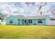 Light teal single story home with a large yard and white fence at 2720 Queen Palm Dr, Edgewater, FL 32141