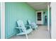 Cozy front porch with two light teal Adirondack chairs at 2720 Queen Palm Dr, Edgewater, FL 32141