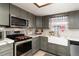 Updated kitchen with gray cabinets, white subway tile backsplash and a farmhouse sink at 2720 Queen Palm Dr, Edgewater, FL 32141