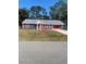 Newly painted home with gray siding, red accents, and a large yard at 2723 Juniper Dr, Edgewater, FL 32141