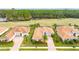 Aerial view of home with brick driveway, tile roof, and lush landscaping near the golf course at 2824 S Asciano Ct, New Smyrna Beach, FL 32168